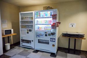 a large white refrigerator with drinks in it at Hotel Machida Villa in Machida