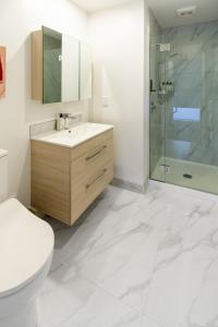 een badkamer met een toilet, een wastafel en een douche bij Sun soaked Central Townhouse 2 bed 2 bath in Christchurch