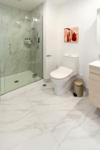 een witte badkamer met een toilet en een douche bij Sun soaked Central Townhouse 2 bed 2 bath in Christchurch