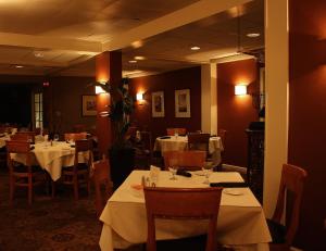 un restaurant avec des tables, des chaises et des nappes blanches dans l'établissement Macaluso's at the Lantern Lodge, à Jim Thorpe