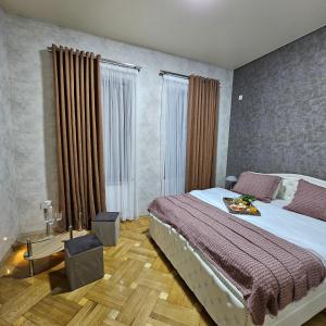 a bedroom with a large bed and some windows at Memory basket in Kutaisi