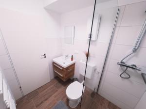 Baño blanco con aseo y lavamanos en ImmoStay #6 - Ferienhaus 4 Zimmer für 8 Personen, WiFi & Zentrum Bremen en Bremen