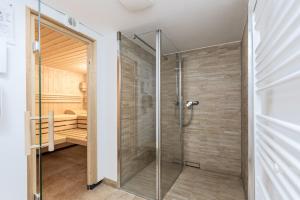 una porta doccia in vetro in un bagno con una camera da letto di Residenz Capitello, App 06 - am Kurpark, Strandnah a Telgte