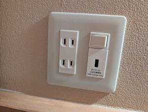a white light switch on the side of a wall at Guest House Tokyo Samurai in Tokyo