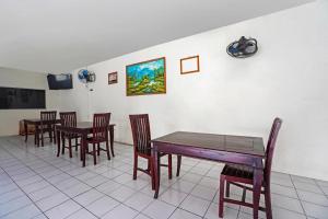 a dining room with wooden tables and chairs at d Ritz residence in Surabaya