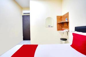 um quarto com uma cama vermelha e branca num quarto em De Plaza Hotel em Surabaya