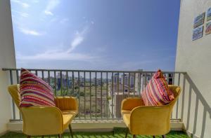 2 sillas sentadas en un balcón con vistas en Coral BnB Premium 2 BHK Apartment - 5 km from Dabolim Airport, en Vasco Da Gama