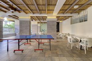 una mesa de ping pong en una habitación con mesas y sillas en Coral BnB Premium 2 BHK Apartment - 5 km from Dabolim Airport, en Vasco Da Gama