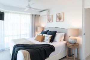 a bedroom with a bed with pillows and a ceiling fan at Noosa Pacific Resort in Noosaville