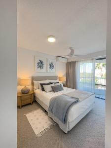 Un dormitorio con una cama grande y una ventana en Noosa Pacific Resort, en Noosaville