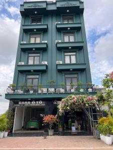 zielony budynek z kwiatami przed nim w obiekcie Sky Hotel w mieście Bắc Giang