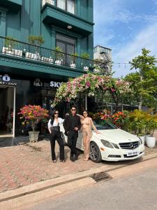 Bắc Giang的住宿－Sky Hotel，一群人站在一辆白色汽车旁边