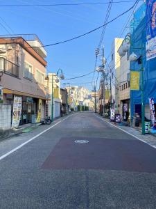 東京 足立区青井 Tokyo Adachiku Aoi في طوكيو: شارع فاضي في مدينه فيها مباني