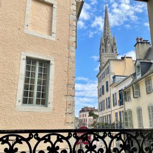 een balkon met uitzicht op een gebouw met een kathedraal bij Quartier historique et populaire du château de Pau in Pau