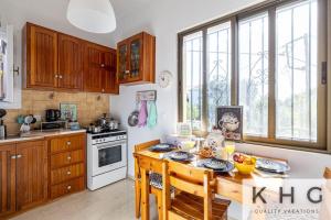 a kitchen with wooden cabinets and a wooden table at Théa Lassi 2 bedroom apartment, First floor in Argostoli