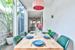 a wooden table with green chairs and a dining room at Astounding 3 Bedroom House Surry Hills 2 E-Bikes Included in Sydney