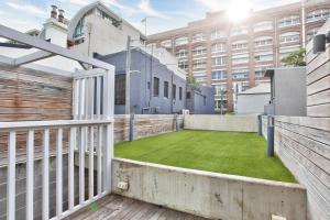 a balcony with a green lawn in front of a building at Astounding 3 Bedroom House Surry Hills 2 E-Bikes Included in Sydney