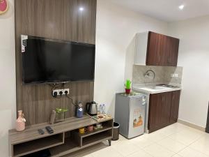 a kitchen with a sink and a tv and a refrigerator at استديو أنيق بدخول ذاتي in Al Kharj