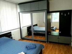 a bedroom with a bed and a large mirror at Apartment Stoyanovi in Primorsko