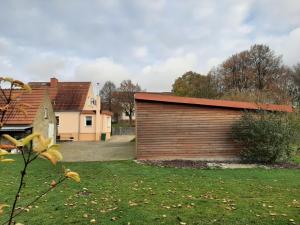 a wooden garage with a red roof in a yard at MV Idyll in Dahmen