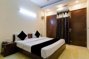 a bedroom with a large bed with a wooden door at Hotel Royal Red Rohini Sector 23 in New Delhi