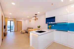 a kitchen with white cabinets and a dining room at Aria Vũng tàu in Vung Tau
