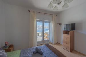 a bedroom with a bed and a television and a window at Diana mountain and seaview in Metajna