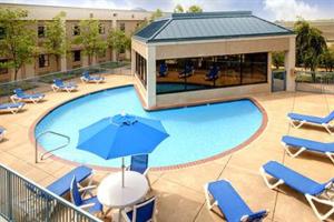 - une piscine avec des chaises et un parasol dans l'établissement Americas Best Value Inn - Tunica Resort, à Robinsonville