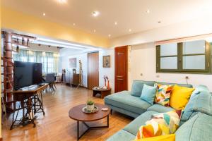 een woonkamer met een blauwe bank en een tafel bij Lito's Central Gem - Cozy Dream Getaway in Kalamata