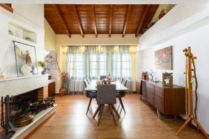 een eetkamer met een tafel en een open haard bij Lito's Central Gem - Cozy Dream Getaway in Kalamata