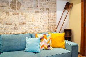 un sofá azul con almohadas coloridas en la sala de estar. en Lito's Central Gem - Cozy Dream Getaway, en Kalamata