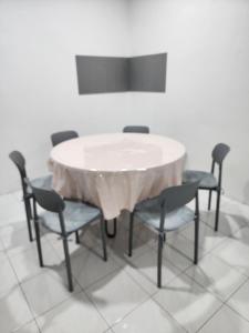 a dining room table with chairs and a white table at DE ELITE KUCHING HOMESTAY in Kuching