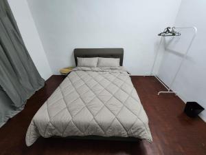 a bedroom with a bed with a gray comforter at DE ELITE KUCHING HOMESTAY in Kuching