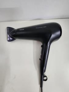 a black hair dryer hanging on a wall at DE ELITE KUCHING HOMESTAY in Kuching +5 photos