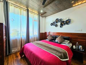 a bedroom with a large bed with a pink blanket at THE TULIP BIR in Bīr