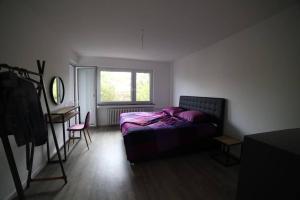 a bedroom with a bed and a desk and a window at Designer-Apartment near Düsseldorf+Cologne (Apt.3) in Neuss