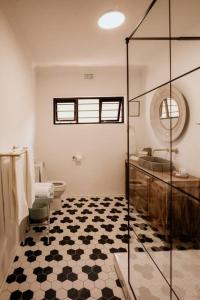 a bathroom with a shower and a toilet and a sink at Spacious home with pool 200M from beach in Cape Town