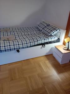 1 dormitorio con 1 cama y suelo de madera en Ursynow Apartament WAW Lanciego, en Varsovia