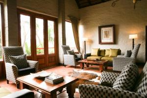a living room with couches and chairs and a table at Entabeni Mountain Lodges in Golders Green