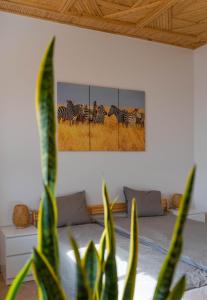 ein Schlafzimmer mit einem Zebrasgemälde an der Wand in der Unterkunft Dar Makai Surf Hotel in Tamraght Ouzdar