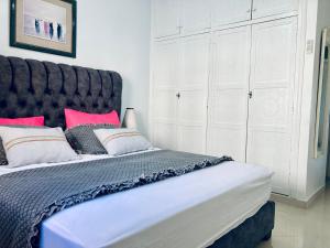 una camera da letto con un grande letto con cuscini rossi di Confortables location familiale vue sur mer à Sidj Fredj a Staoueli