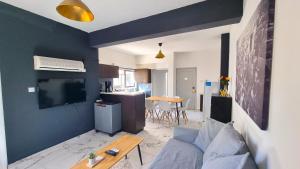 a living room with a couch and a tv and a kitchen at Cozy Beach Apt / Near Airport + 100Mbit internet + Netflix in Larnaka
