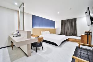 um quarto de hotel com uma cama e uma secretária em Calm Rest Hotel Busan Sasang em Busan