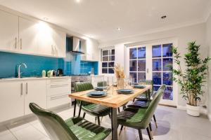 a kitchen with a wooden table and green chairs at City Center 2 Bedroom House Pyrmont 2 E-Bikes Included in Sydney