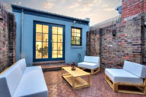 a patio with two white chairs and a table at City Center 2 Bedroom House Pyrmont 2 E-Bikes Included in Sydney