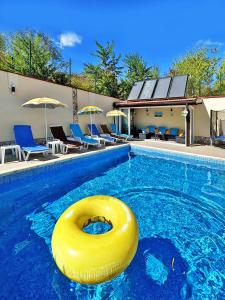 a large swimming pool with a yellow rubber ring in the water at Villa Regina Bella in Balchik