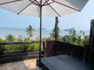 un patio con una sombrilla y el océano en Phu Samut, en Ban Ba Kan Pa