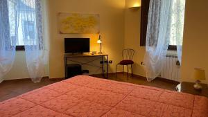 a bedroom with a bed and a desk with a television at La Contessa B&B Palazzo Plantulli in Avellino