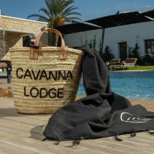 a black blanket and a bag next to a pool at Cavanna Lodge in Essaouira