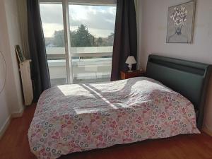 a bedroom with a bed with a view of a window at Joli appartement bien situé pour les JO in Les Essarts-le-Roi